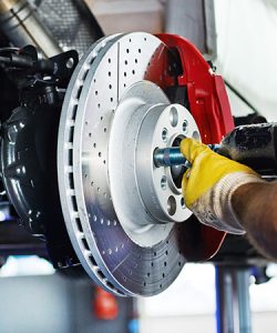 Car mechanic in a garage repairs a bracke